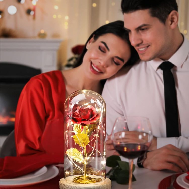 Enchanted eternal rose in glass dome presented as romantic Valentine's Day gift with pink packaging