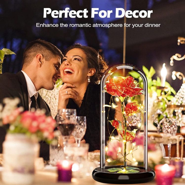 Galaxy rose illuminated by colorful LED lights creating romantic flashing effects in glass dome